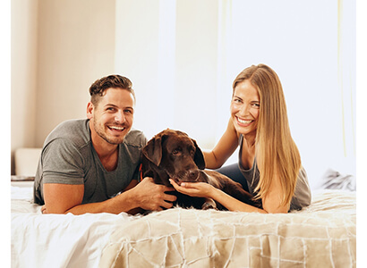 a young Couple with a dog Lying On The Bed, Humans Care More about Their Pets, stuff-petslove