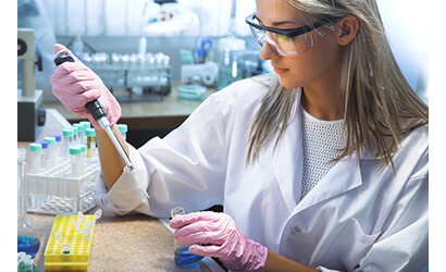 a female is testing a sample in a lab