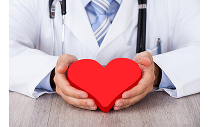 Doctor holding a toy heart in his hands